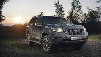 Toyota Land Cruiser schlammbespritzt in unwegsamen Gelände in der Abenddämmerung