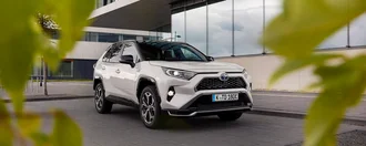 Weißer Toyota Rav4 von vorne aus einem Gebüsch raus fotografiert