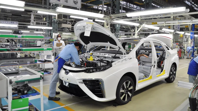 Informationen zum Kundendienst beim Autohaus Goos in Nürtingen Ein Mechaniker repariert einen weißen, auseinander gebauten Toyota